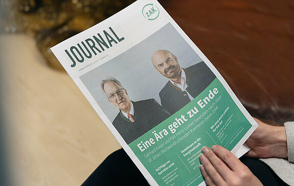 Person hält das ZAK Journal in der Hand – eine jährlich erscheinende Broschüre des Zweckverbands für Abfallwirtschaft Kempten.