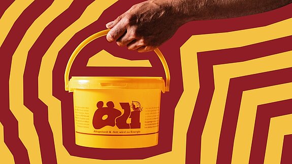 Gelber Eimer mit Aufschrift "Öli" wird von einer Hand vor einem rot-gelben Hintergrund gehalten.